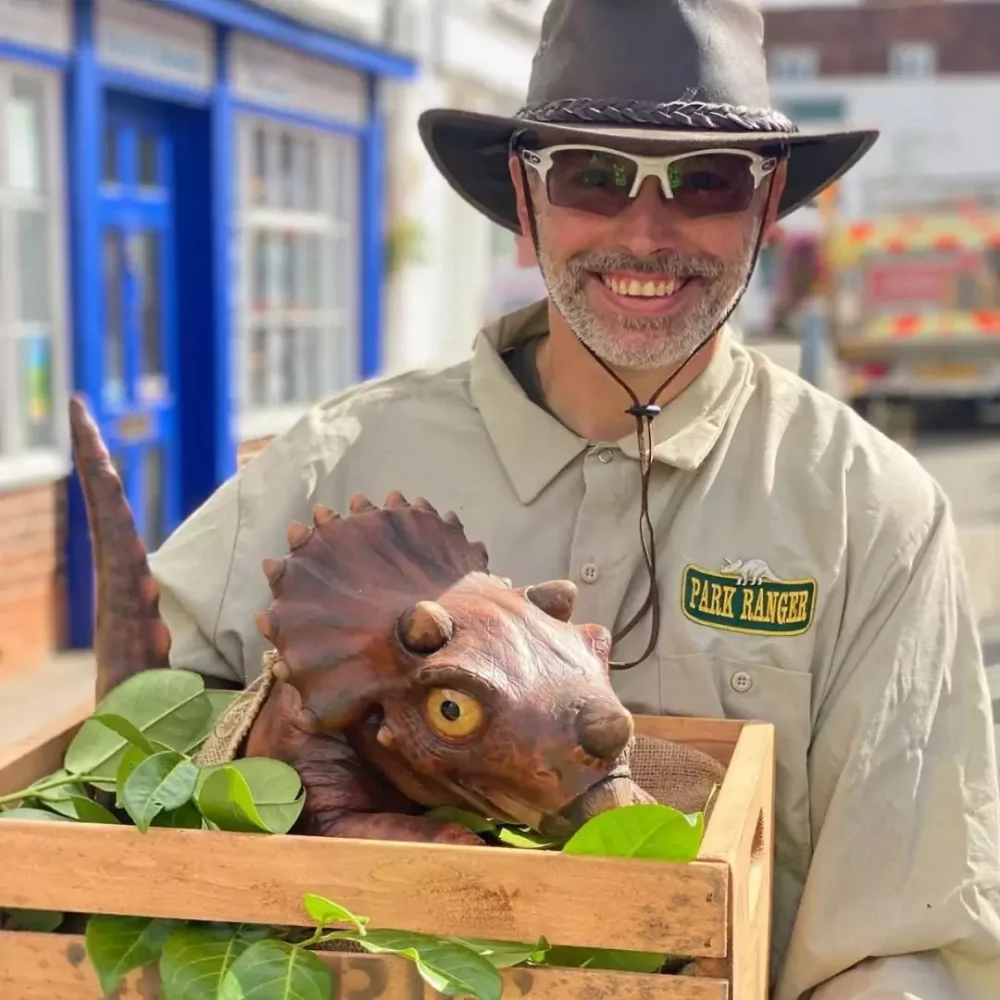 A dinosaur presenter with a baby Triceratops