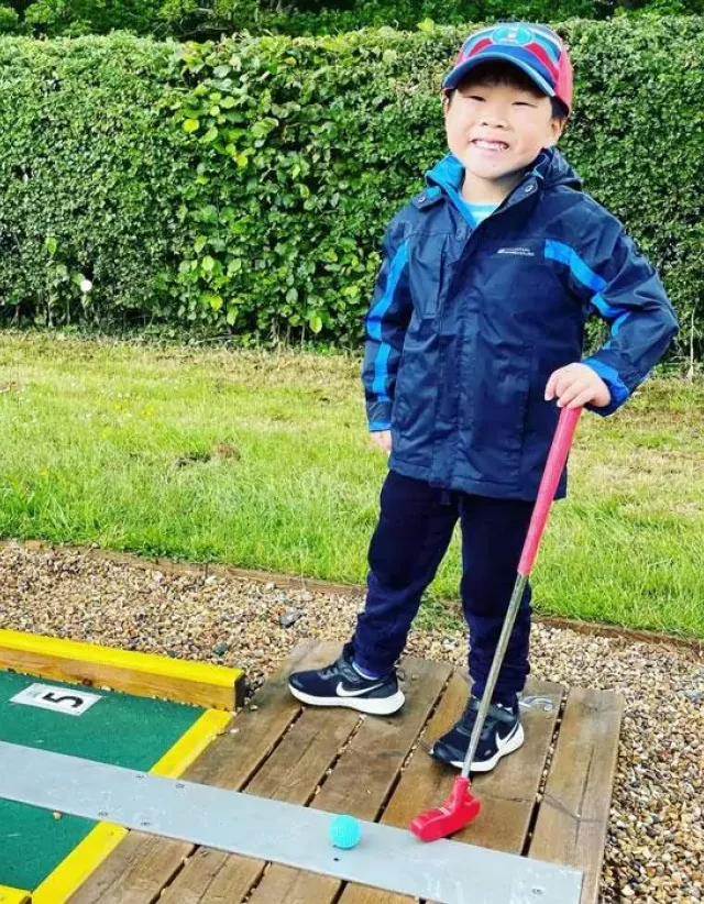 A child playing mini golf