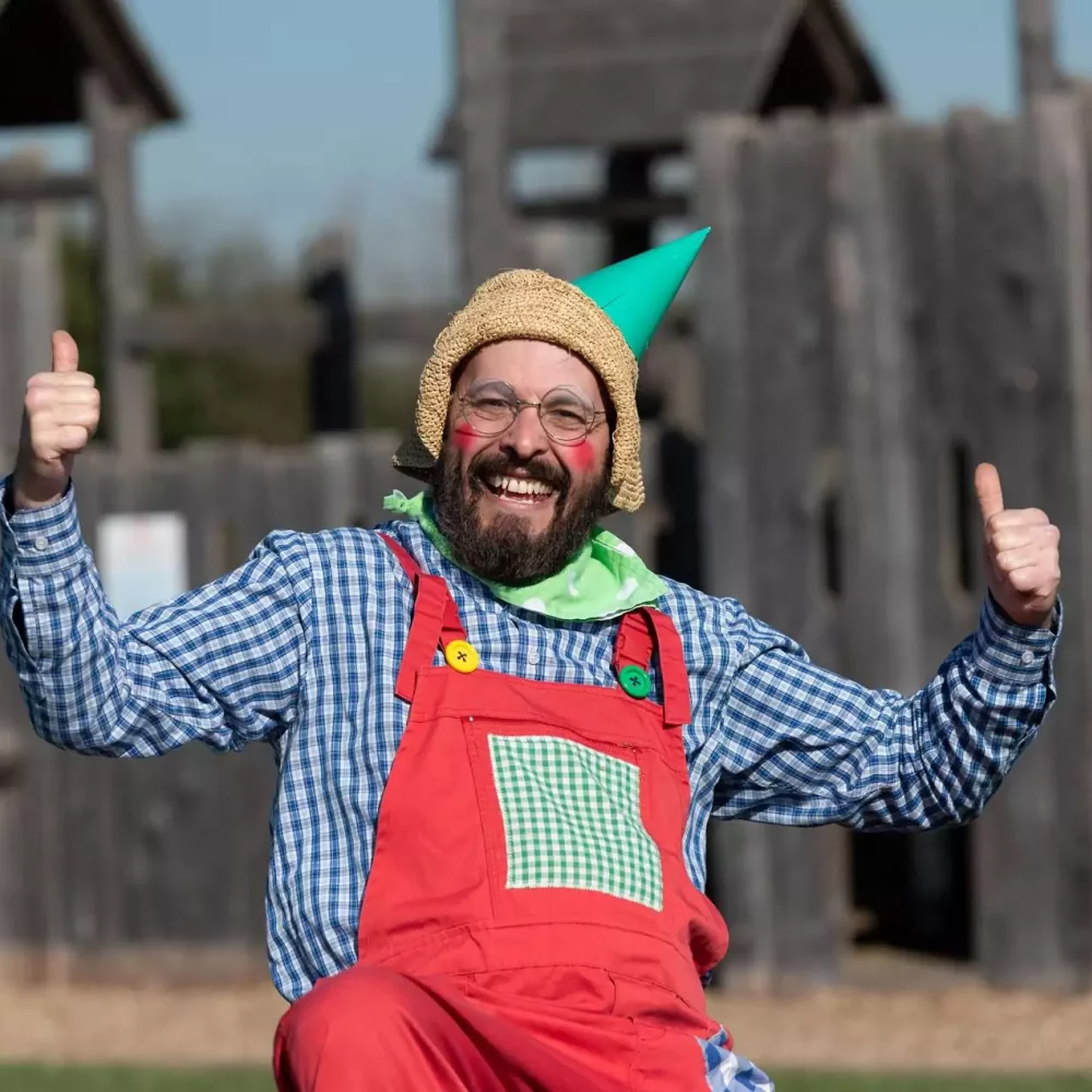 A performer in a colourful costume entertaining families