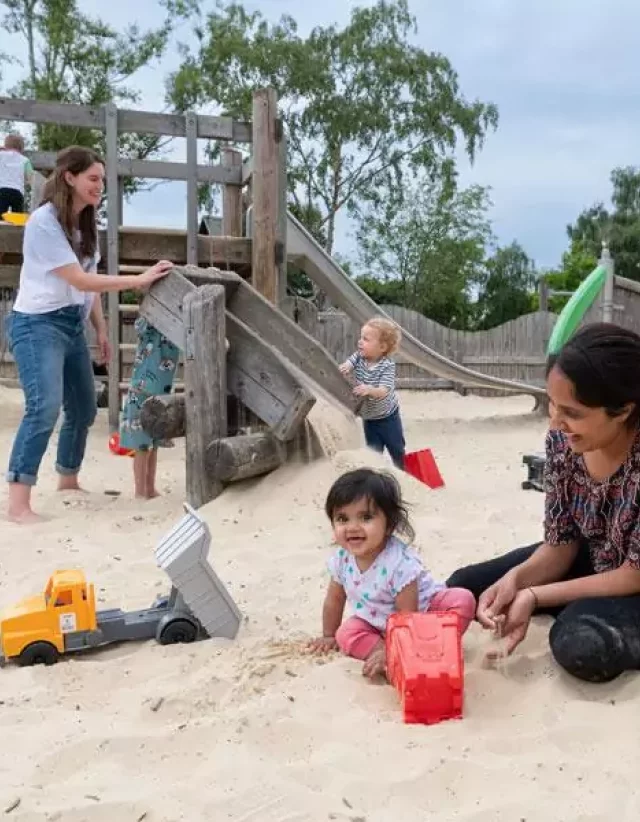 Families enjoying the outdoor sand play area